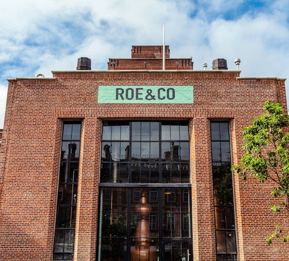 Roe & Co Distillery entrance with brick facade and large glass windows in Dublin.