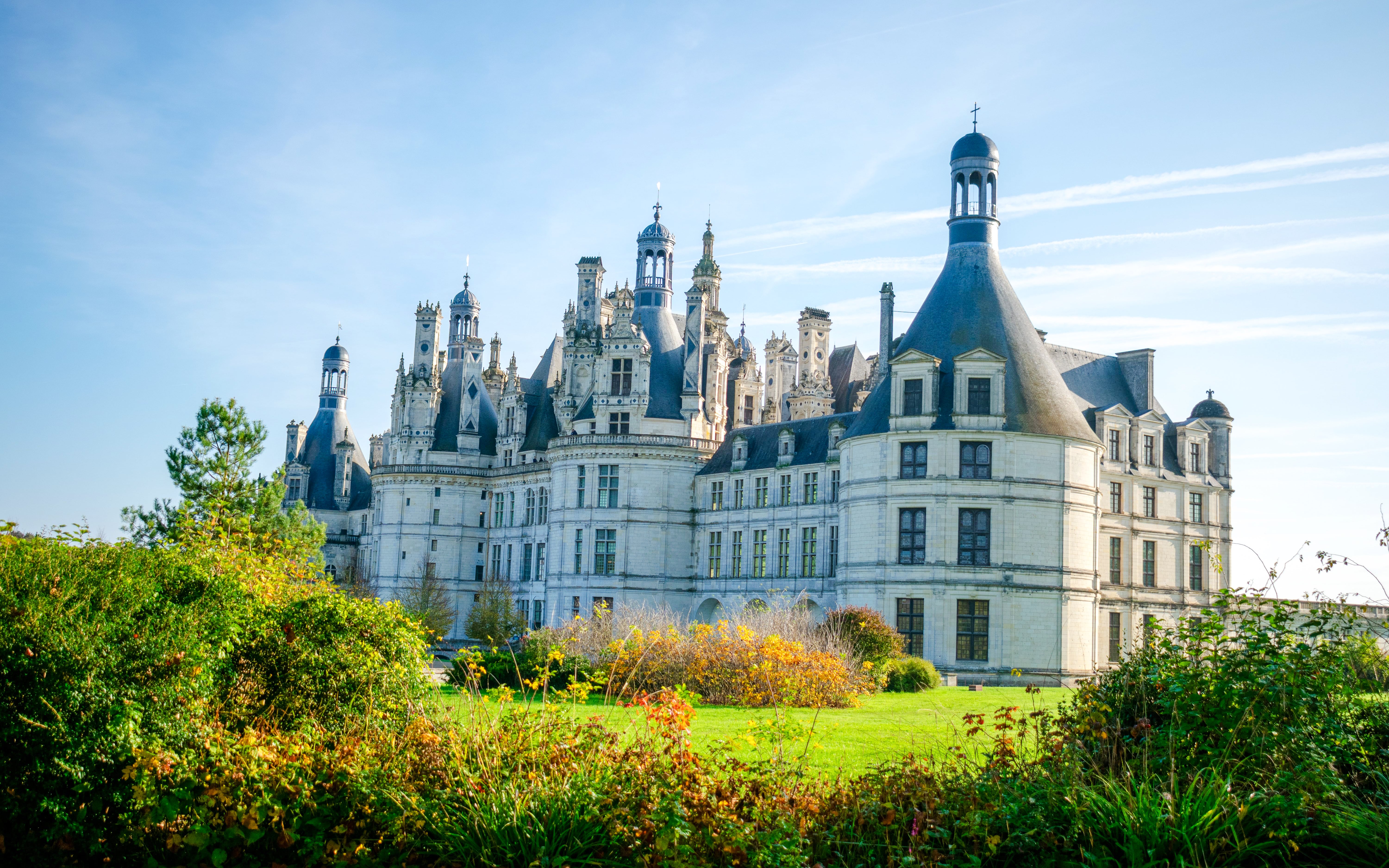 Chambord Castle in France with lush gardens in the foreground.