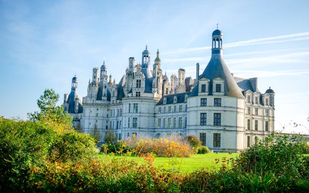 Chambord Castle in France with lush gardens in the foreground.