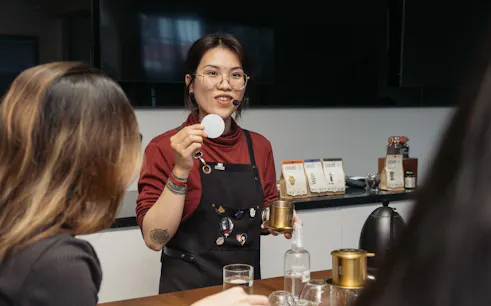 Vietnamese coffee workshop with instructor demonstrating brewing techniques.