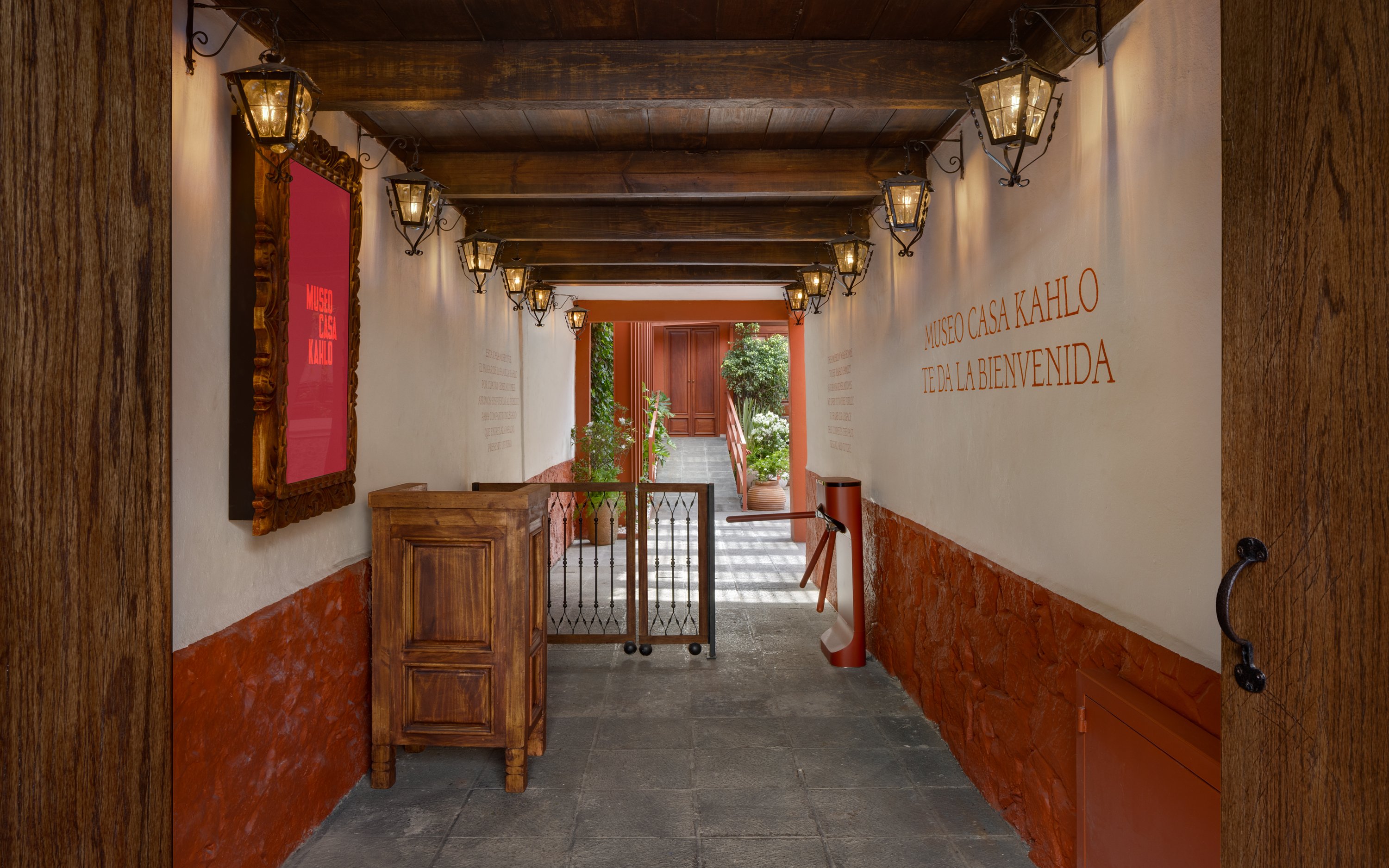 Entrance hallway of Museo Casa Kahlo with wooden beams and lanterns.