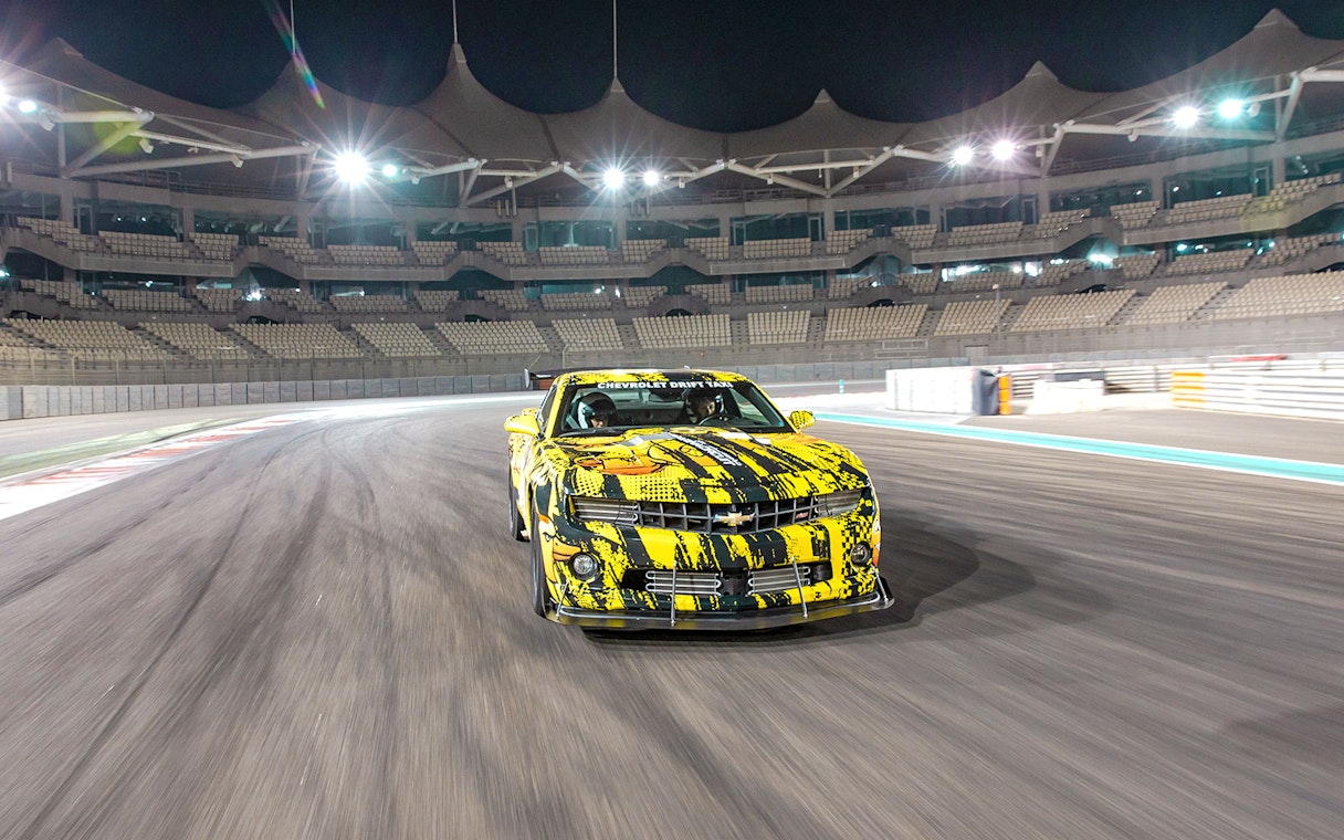 Chevrolet car drifting at Yas Marina Circuit during night tour experience.