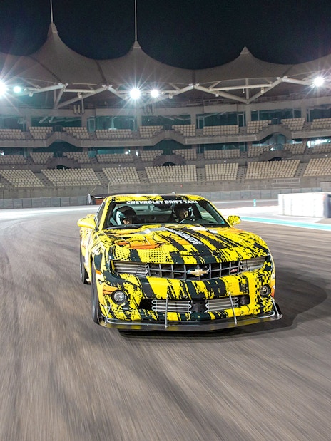 Chevrolet car drifting at Yas Marina Circuit during night tour experience.