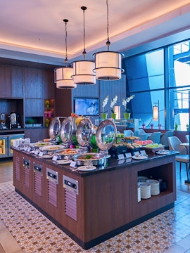 Buffet spread at Plaza Premium Lounge Jakarta with seating area and modern decor.