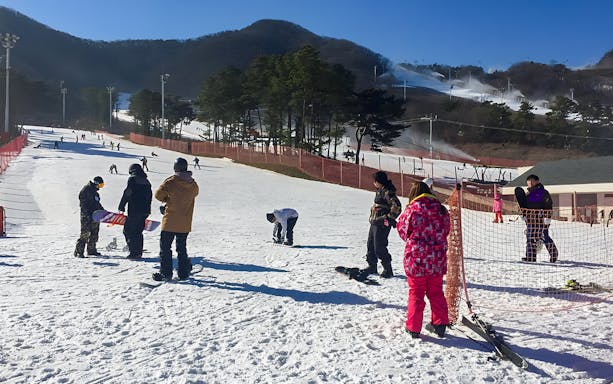Visitors preparing to snowboard at Jisan Forest Ski Resort near Seoul.