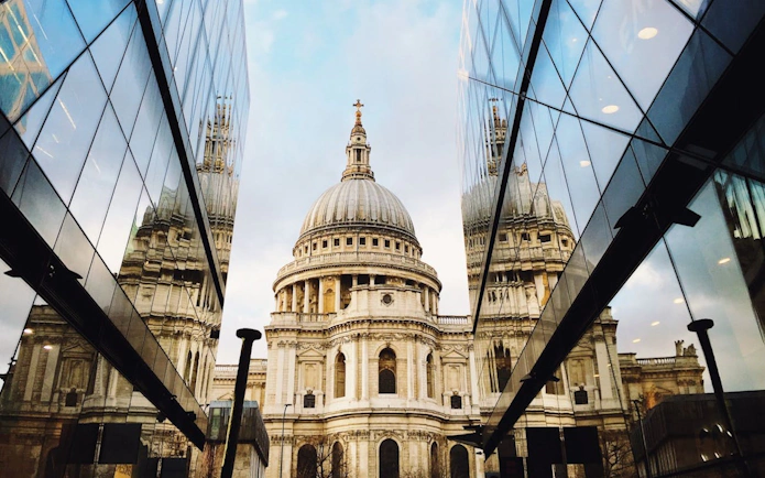 St. Paul's Cathedral reflected in modern glass buildings, London sightseeing tour.