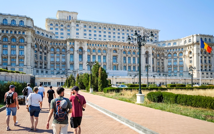 Visitors walking outside the Palace of Parliament in Bucharest, Romania.