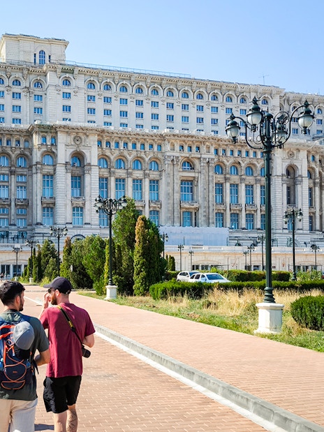 Visitors walking outside the Palace of Parliament in Bucharest, Romania.