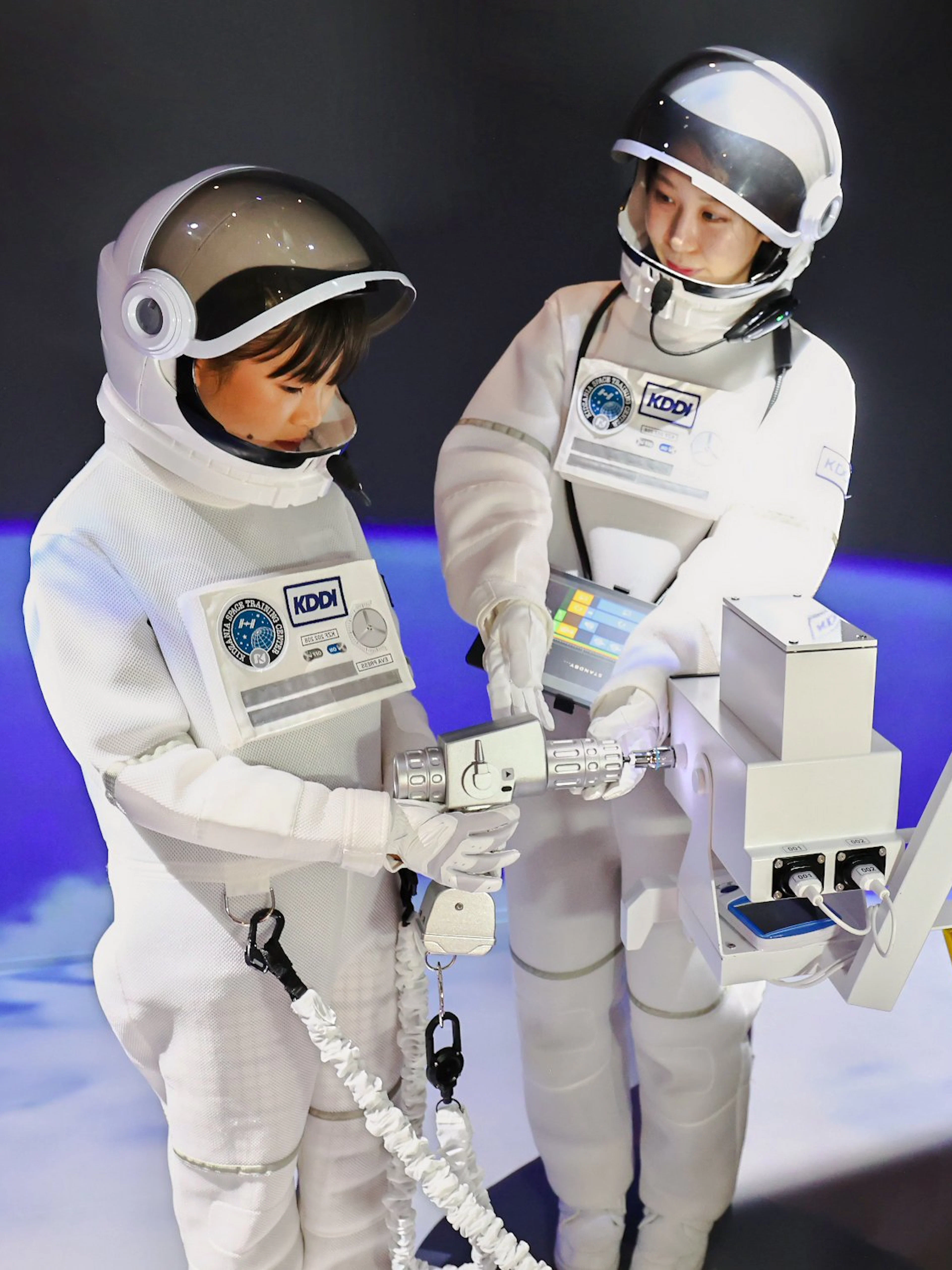 Children in astronaut suits interacting with a spaceship module at KidZania Fukuoka.