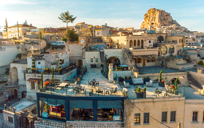 Cappadocia stone buildings and terraces with Uçhisar Castle in the background.