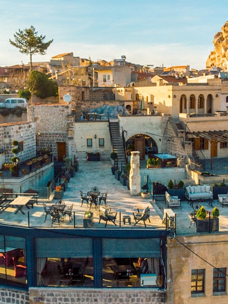 Cappadocia stone buildings and terraces with Uçhisar Castle in the background.