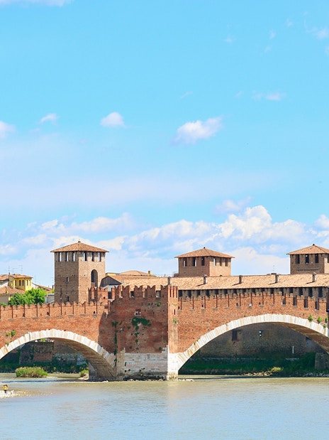 Verona's Castelvecchio Bridge over the Adige River on a sunny day.