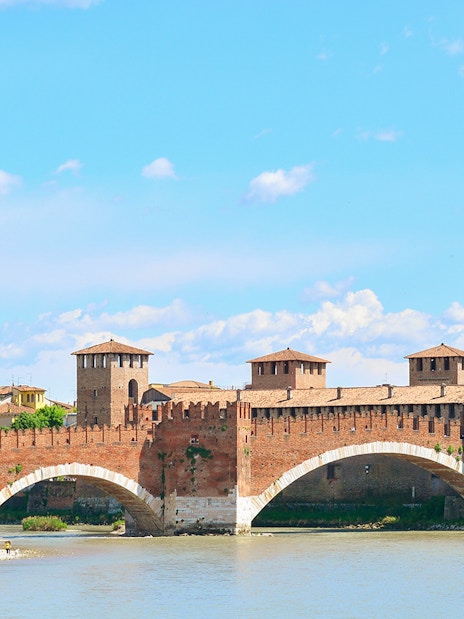 Verona's Castelvecchio Bridge over the Adige River on a sunny day.
