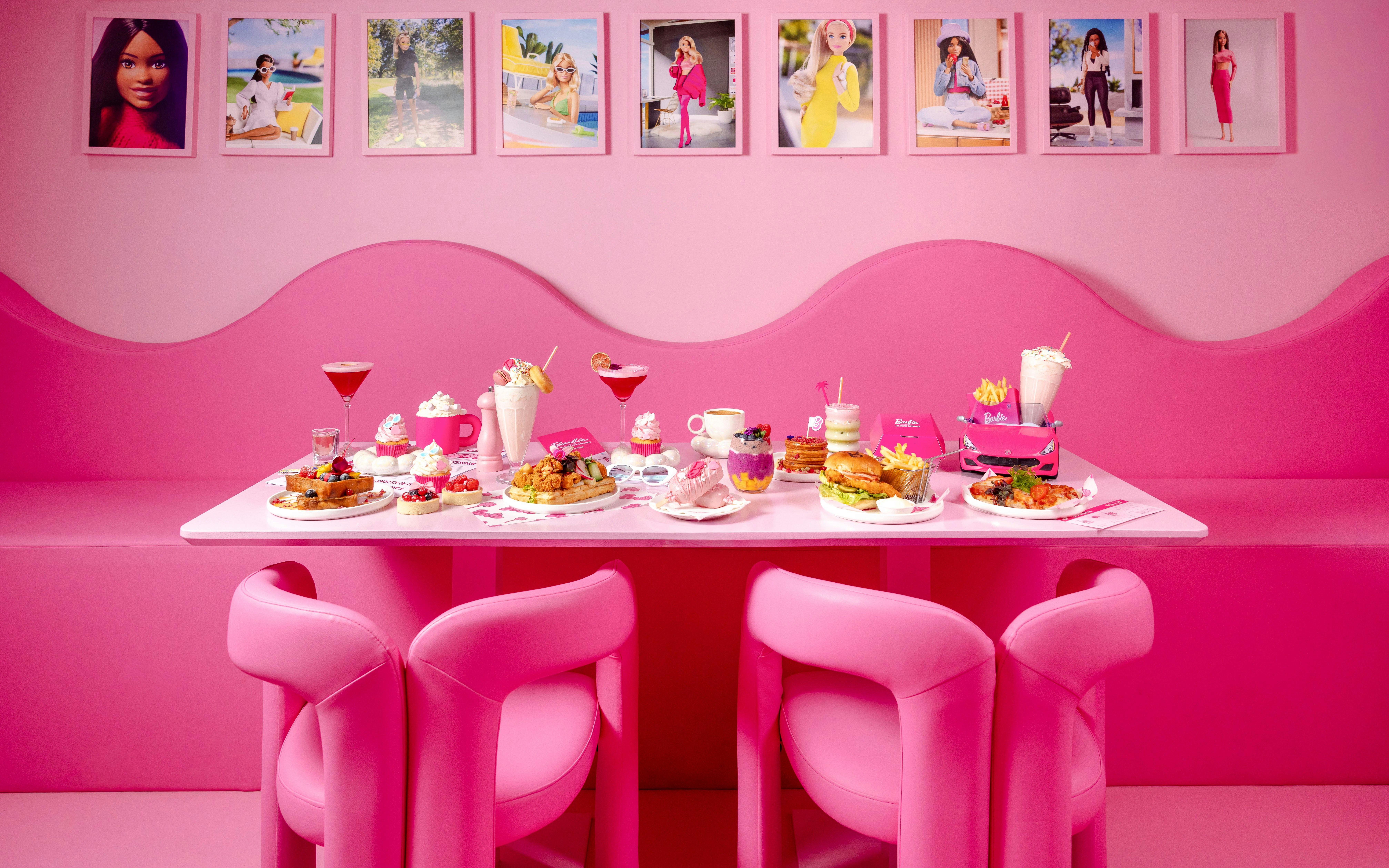 Pink-themed cafe table with assorted desserts and drinks at Barbie, The Dream Experience.