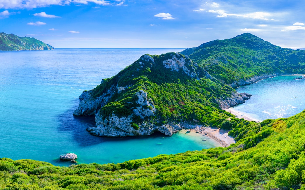 Agios Stefanos cape in Corfu with lush greenery and turquoise waters.