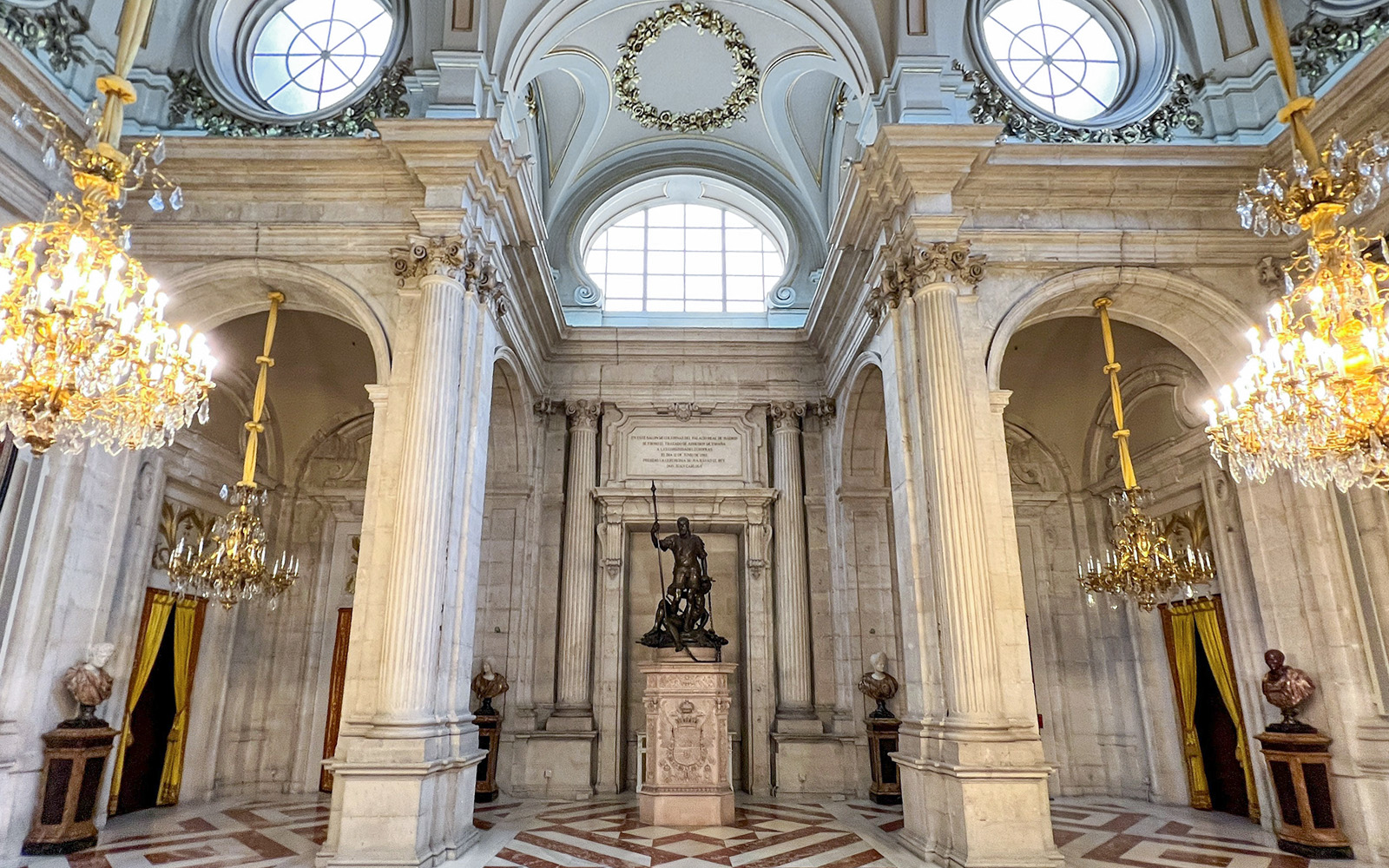 Hall of columns with chandeliers and statue, Royal Palace of Madrid.