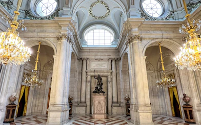 Hall of columns with chandeliers and statue, Royal Palace of Madrid.
