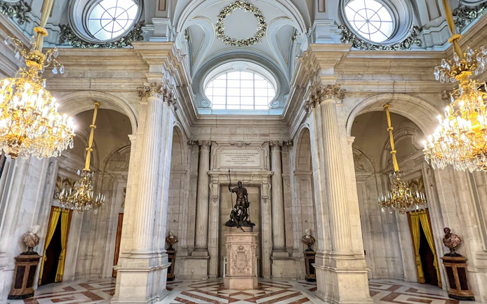 Hall of columns with chandeliers and statue, Royal Palace of Madrid.