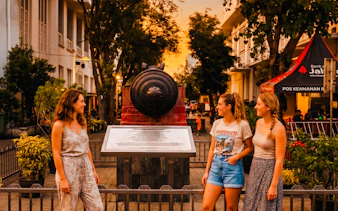 Tourists exploring historical cannon in Jakarta's Kota Tua during Chinatown Glodok Food Tour.