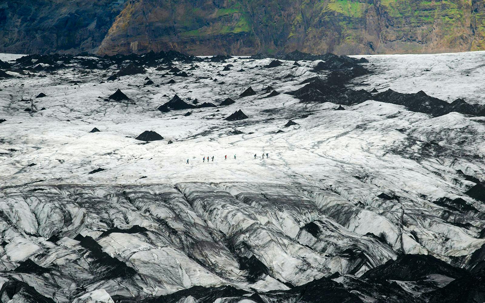 Hikers traversing Solheimajökull Glacier in Iceland.