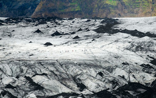 Hikers traversing Solheimajökull Glacier in Iceland.