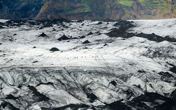 Hikers traversing Solheimajökull Glacier in Iceland.