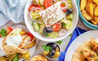 Greek salad, pita with tzatziki, olives, and potato wedges served on a cruise lunch.