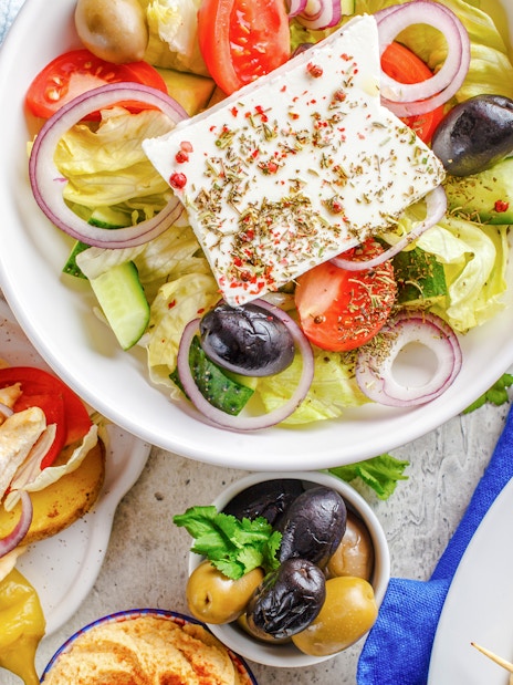 Greek salad, pita with tzatziki, olives, and potato wedges served on a cruise lunch.