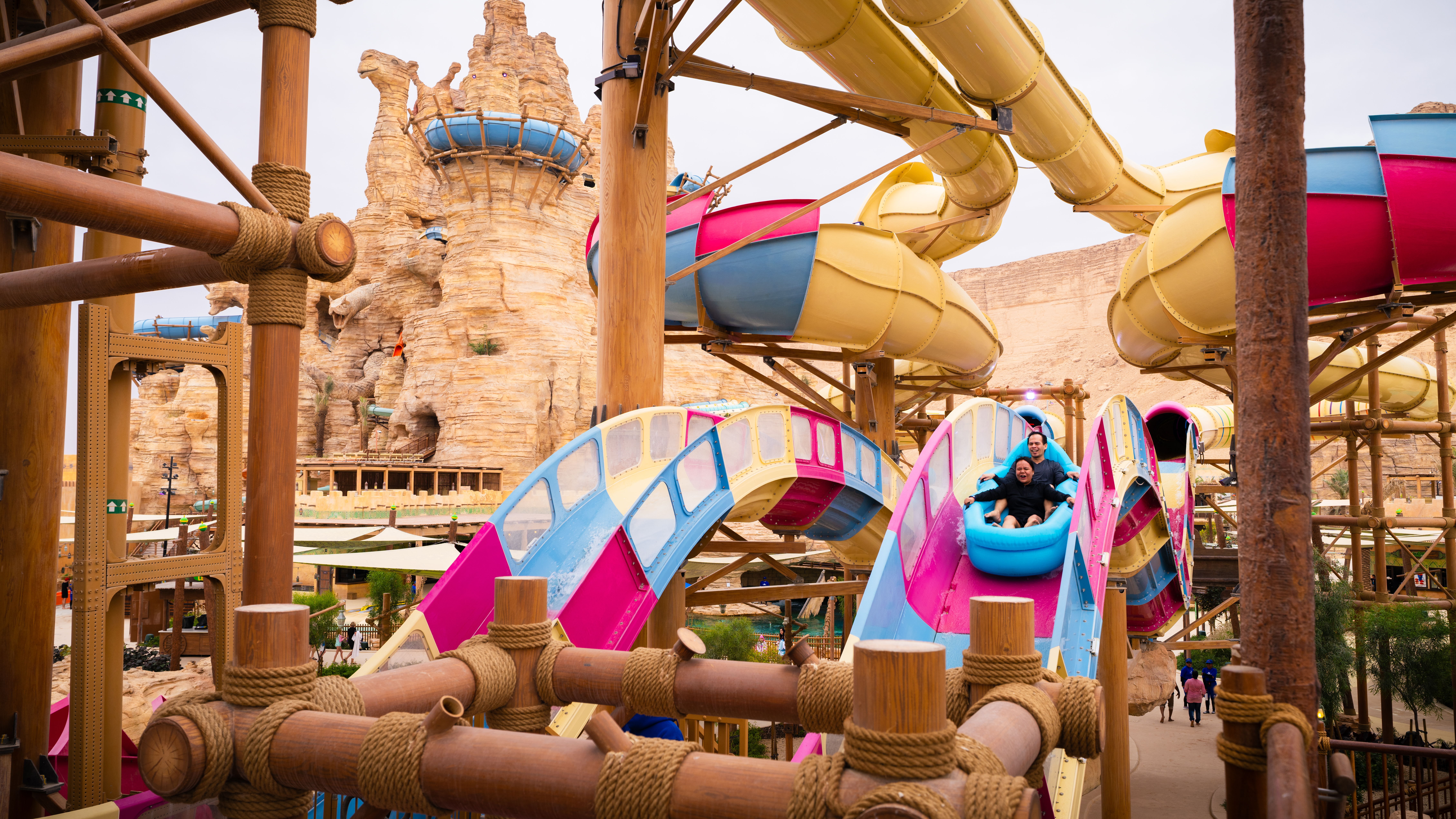 Visitors enjoying a colorful water slide at Aquarabia Water Theme Park, Qiddiya City, Saudi Arabia.
