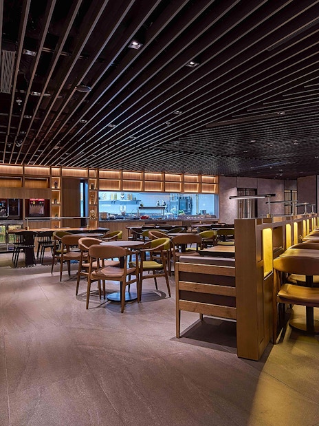 Plaza Premium First lounge seating area with dining tables and buffet counter at Satellite Terminal.