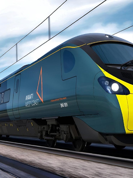 High-speed train traveling through countryside on Lake District day tour from London.