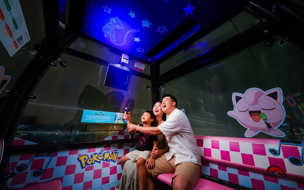 Family enjoying a Pokemon-themed cable car ride in Sentosa, Singapore.