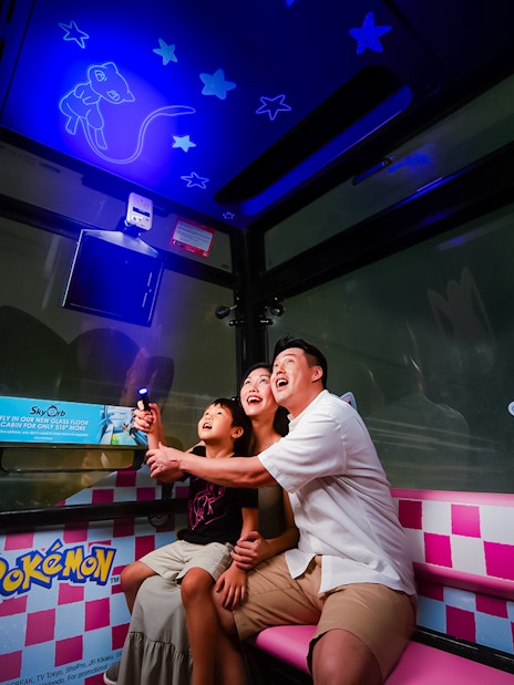 Family enjoying a Pokemon-themed cable car ride in Sentosa, Singapore.