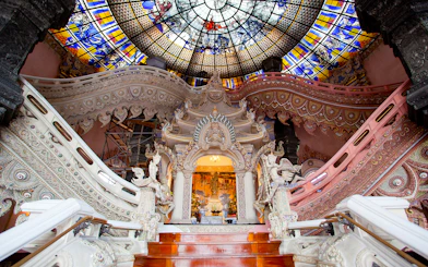 Erawan Museum interior with ornate staircase and stained glass ceiling, Bangkok, Thailand.