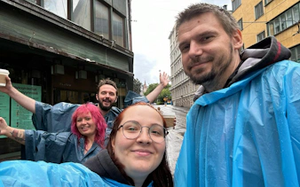 Participants in rain ponchos enjoying Helsinki Murder Mystery city exploration game.