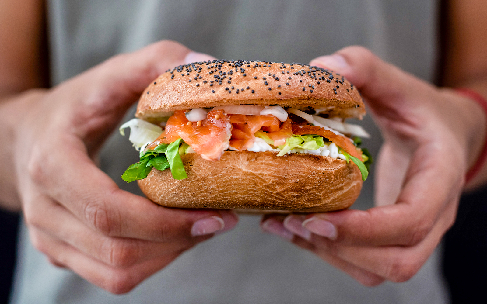 Lox bagel with cream cheese and greens, close-up view.