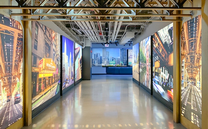 Interactive exhibit hallway at Skydeck Chicago, Willis Tower, featuring cityscape images.