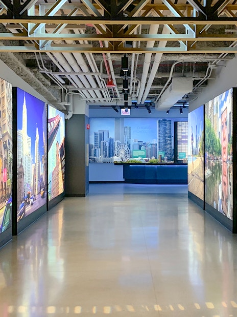 Interactive exhibit hallway at Skydeck Chicago, Willis Tower, featuring cityscape images.