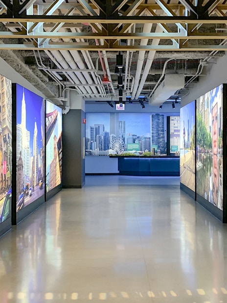 Interactive exhibit hallway at Skydeck Chicago, Willis Tower, featuring cityscape images.
