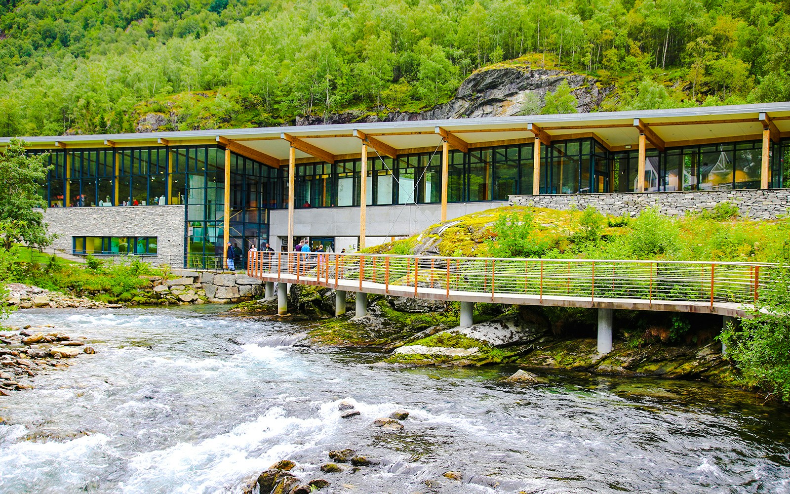 Norwegian Fjord Centre with glass facade and bridge over stream near Geiranger, Norway.