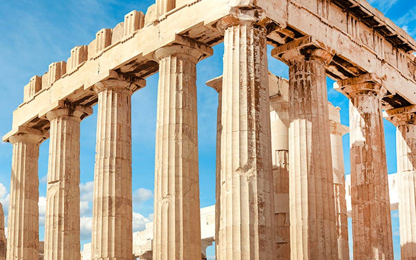 Parthenon columns under blue sky in Athens, Greece.