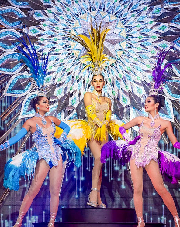 Performers in vibrant costumes on stage at Alcazar Cabaret, Pattaya, Thailand.