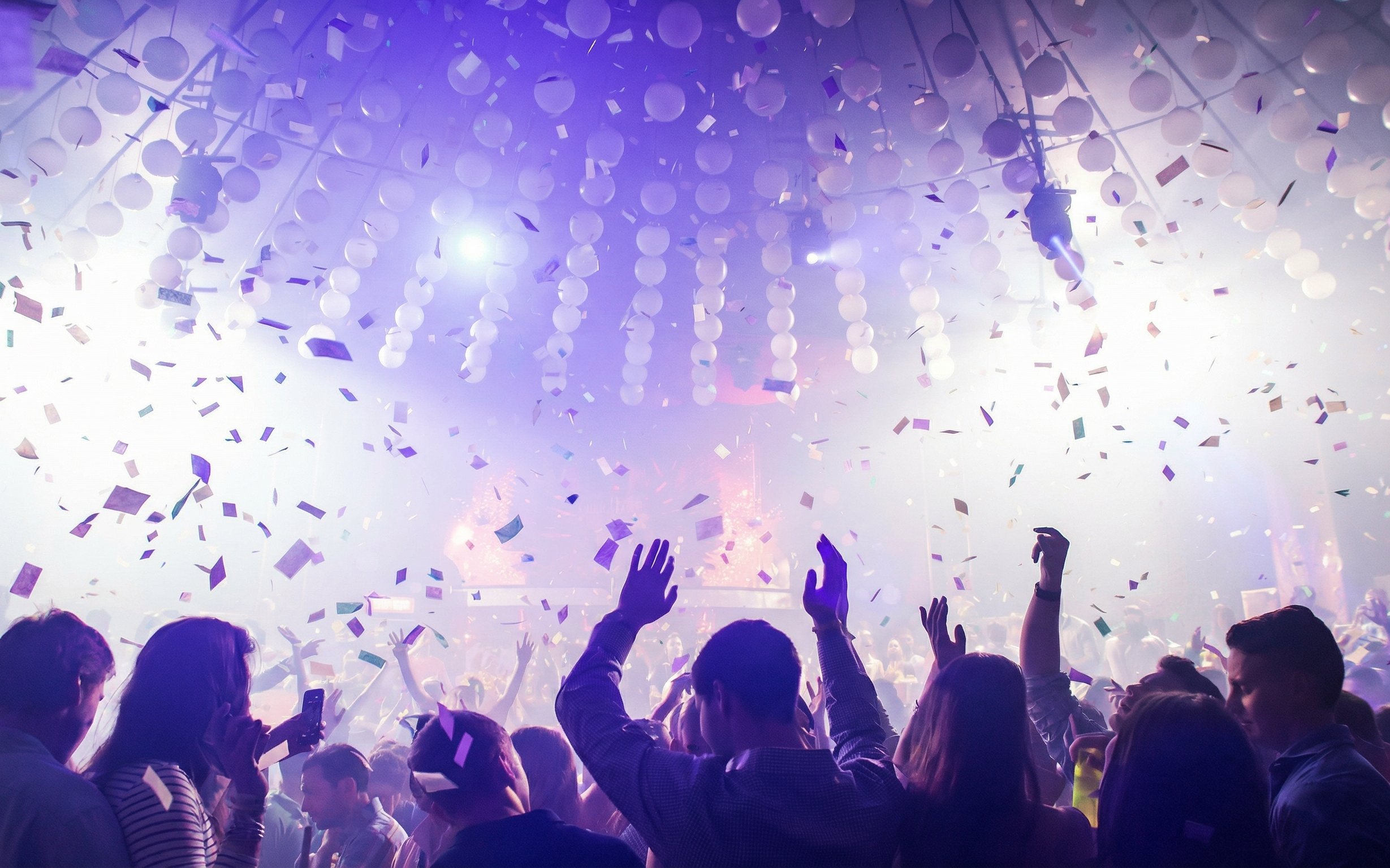 Crowd dancing under confetti at Mandala Nightclub in Cancun.
