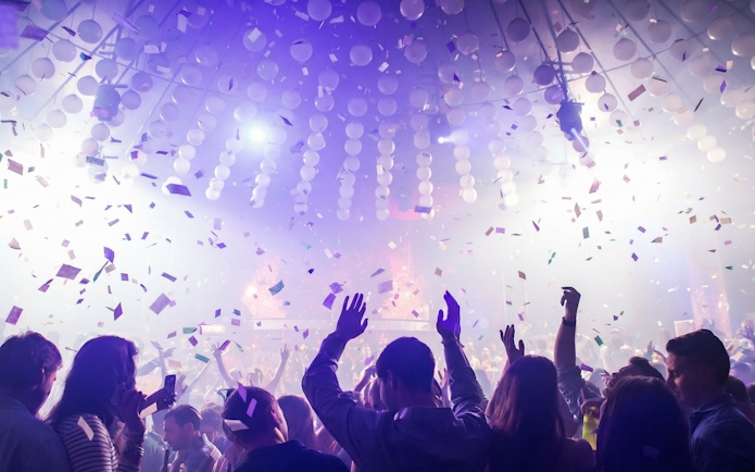 Crowd dancing under confetti at Mandala Nightclub in Cancun.