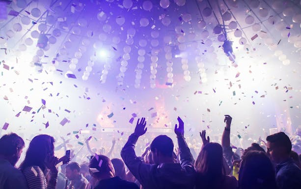 Crowd dancing under confetti at Mandala Nightclub in Cancun.