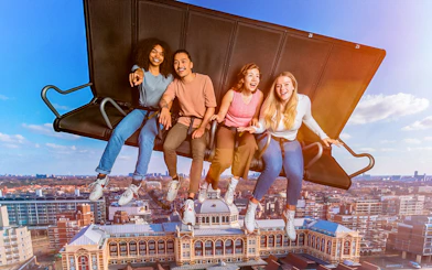 Tourists experiencing 5D ride at This Is Holland, flying over Amsterdam cityscape.