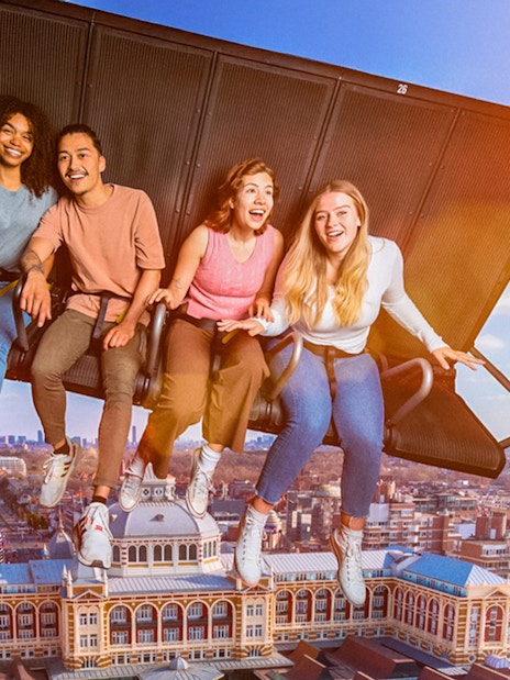 Tourists experiencing 5D ride at This Is Holland, flying over Amsterdam cityscape.