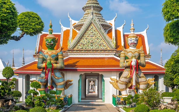 Giant guardian statues at Wat Arun temple in Bangkok.