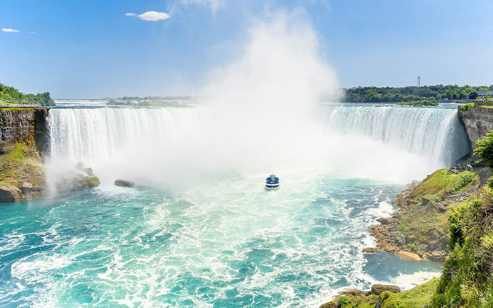 Maid of the Mist boat approaching Niagara Falls, USA, with tourists experiencing the waterfall up close.