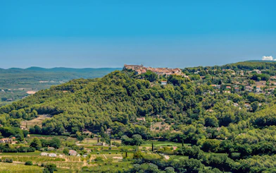 Hilltop village surrounded by vineyards in Bandol, France, under a clear blue sky.